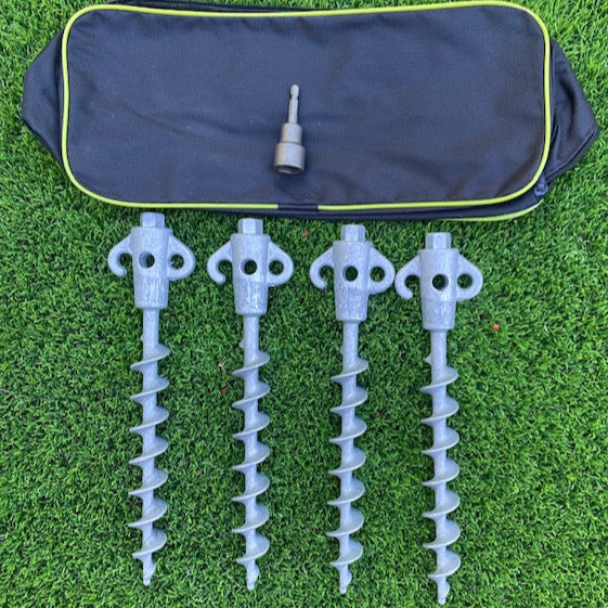 Set of four gray drill bits with a carrying case on a green grass background